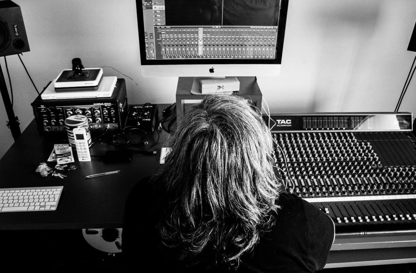Una sesión de mezcla frente a una consola de audio
