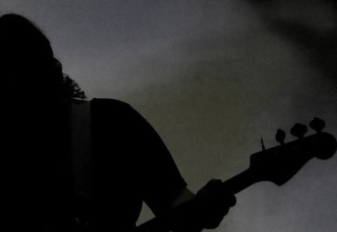 Silueta de un bajista bajo la iluminación del escenario