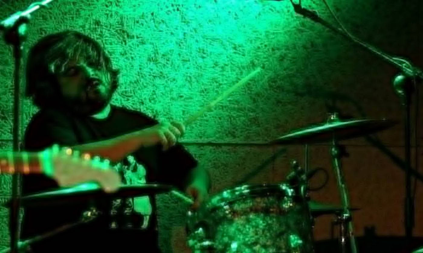 Batería tocando bajo luces verdes